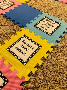 colorful foam mats with words on them sitting on the floor in front of a carpet