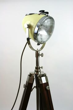 an old fashioned lamp is sitting on a tripod