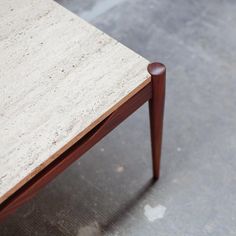 a close up of a small table with wood legs