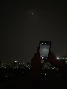 someone is taking a photo with their cell phone at night in the cityscape