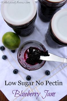 blueberry jam in jars with a spoon on the side and limes next to it