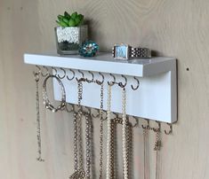 All Original Wall-Mounted Jewelry Organizer - Handmade in the USA Organize your necklaces and bracelets with this beautiful functional shelf!  This hand-crafted shelf adds a touch of charm to your room. The paint color is solid white with visible wood grain and is coated to protect the finish.  Each shelf organizer has silver, gold, or black hooks which can be used for necklace or bracelet storage. The shelf is perfect for rings, watches, pins, etc. Measurements: 10" - 24" wide by 5" tall (including the hooks) and 3.5" deep.  Each jewelry organizer has hooks mounted on the back for easy hanging on your wall. Need a different color or size? Message me and I can use other colors or customize the size to fit your space! Note: variations occur in each piece of wood used to make your one-of-a-k Necklace Organizer Diy, Necklace Holder Wall, Functional Shelf, Jewelry Holder Wall, Jewelry Tree Stand, Black Hooks, Necklace Hanger, Wall Mount Jewelry Organizer, Bracelet Organizer