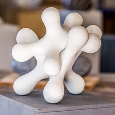 a white sculpture sitting on top of a wooden table