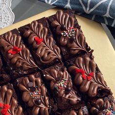 chocolate brownies with sprinkles are on a yellow plate next to a blue and white napkin