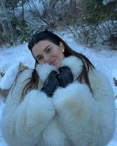 a woman in a fur coat and black gloves posing for the camera with her hands on her chest