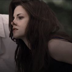 a woman with long brown hair wearing a white shirt