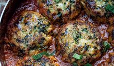 meatballs covered in tomato sauce and fresh herbs