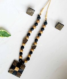 black and gold beaded necklace with matching earring, earrings and pendants on white background