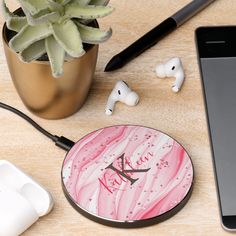 a cell phone and ear buds sitting on a table next to an iphone, plant