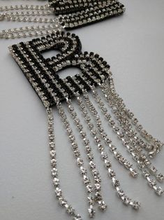 two black and white necklaces with chains hanging from them