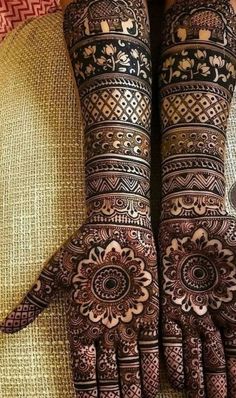 the hands and feet of a woman with henna designs on their arms, both showing intricate