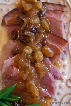 ham with olives and mustard on a white plate