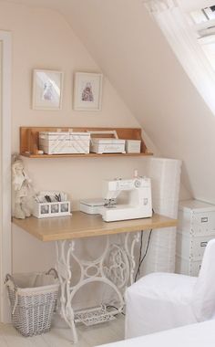 a sewing machine sitting on top of a wooden table next to a white chair in a room