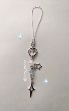 a keychain with charms attached to it on a white surface and stars in the background