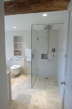 a bathroom with a walk in shower next to a toilet