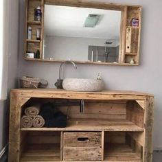 a bathroom with a sink, mirror and wooden cabinet in it's center area