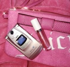 a cell phone and lipstick sitting on top of a pink bag