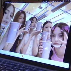 a computer screen with girls holding coffee cups in front of their faces and looking at the camera