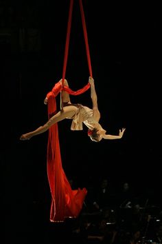 a woman is performing aerial acrobatics on a rope