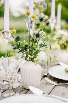 the table is set with flowers and candles