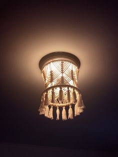 a chandelier with tassels hanging from it's sides in a dark room