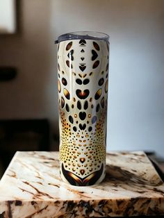 a white and black cup sitting on top of a marble table next to a window