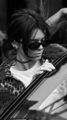 a woman in sunglasses leaning out the window of a car