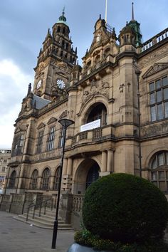 an old building with two towers on top and a clock tower above it's entrance