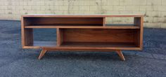 a wooden shelf sitting on top of a parking lot next to a brick wall,