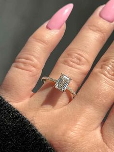 a woman's hand with pink manicured nails and an engagement ring