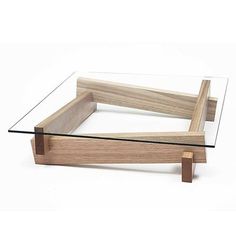 a glass and wood coffee table sitting on top of a white floor