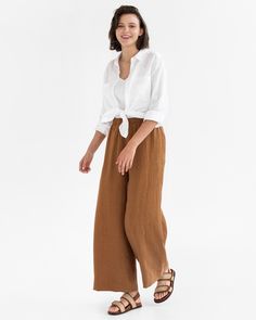 "Upgrade your look with ALCUDIA wide leg linen pants in Cinnamon. These high-rise pants have a stylish wide leg and hit below the ankle (28.5\"/72 cm inseam). They're both fashionable and functional, with side seam pockets for convenient storage and a flattering elastic waist. Perfect for any occasion. Details: * Wide leg design * 2 side seam pockets for added functionality and style * High rise and elastic waist for a flattering fit * Medium weight linen (approx. 200 gsm) * The model is wearing Effortless Relaxed Fit Linen Wide Leg Pants, Spring Brown Relaxed Fit Wide Leg Pants, Casual Brown Linen Wide Leg Pants, Relaxed Fit Linen Wide Leg Pants In Flax Color, Relaxed Fit Flax Linen Wide Leg Pants, Flax-colored Relaxed Fit Linen Wide Leg Pants, Brown Linen Bottoms For Summer, Versatile Linen Wide Leg Pants, Brown Linen Summer Bottoms