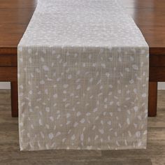 the table is covered with a white and beige patterned cloth that has spots on it