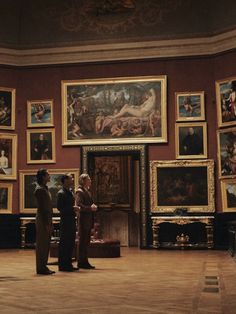 two people are standing in front of paintings