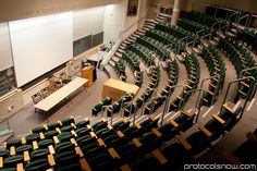 an empty lecture hall filled with green chairs