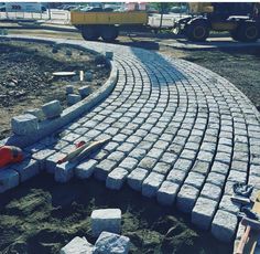 a brick walkway being built in the middle of a construction site with tools laying on it