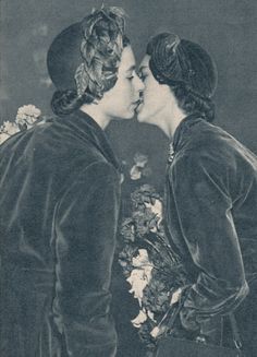 an old photo of two women kissing each other