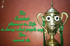 a gold trophy sitting on top of a table next to a red wall with the words, the greatest pleasure in life is doing what people say you cannot do