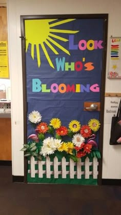 a classroom door decorated with flowers and the words, look who's blooming