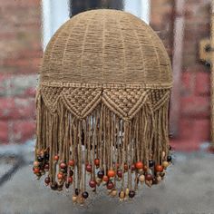 a close up of a woven object with beads and chains hanging from it's side