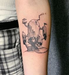 a tattoo on the arm of a person with an alien ship in front of it