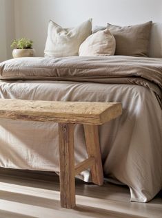 a wooden bench sitting in front of a bed