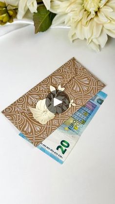 a white flower and some brown paper on a table