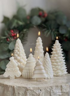 some white christmas trees are sitting on a table