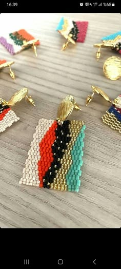 several different colored beaded earrings sitting on top of a wooden table