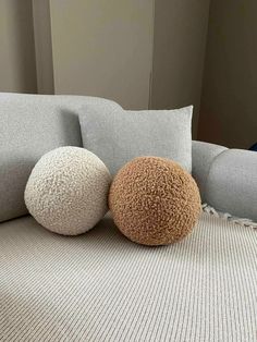 three different colored pillows sitting on top of a couch