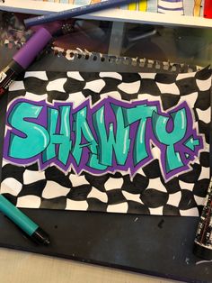 the word shawr is painted on a piece of paper next to markers and pencils