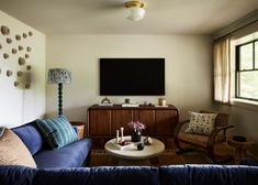 a living room filled with furniture and a flat screen tv mounted to the side of a wall