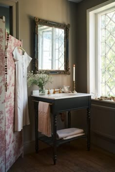 a bathroom sink sitting under a mirror next to a wooden cabinet and window with flowers on it