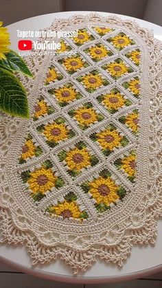 a doily with sunflowers on it sitting on top of a table